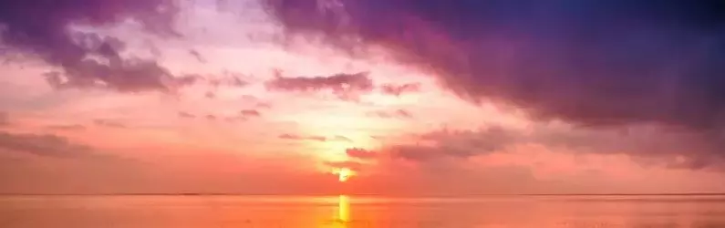 Crépuscule sur la mer avec le soleil rejoignant l’horizon, une image symbolisant la réunion du corps et de l’esprit dans l’article de Christophe Gence commentant une citation de Nietzsche.