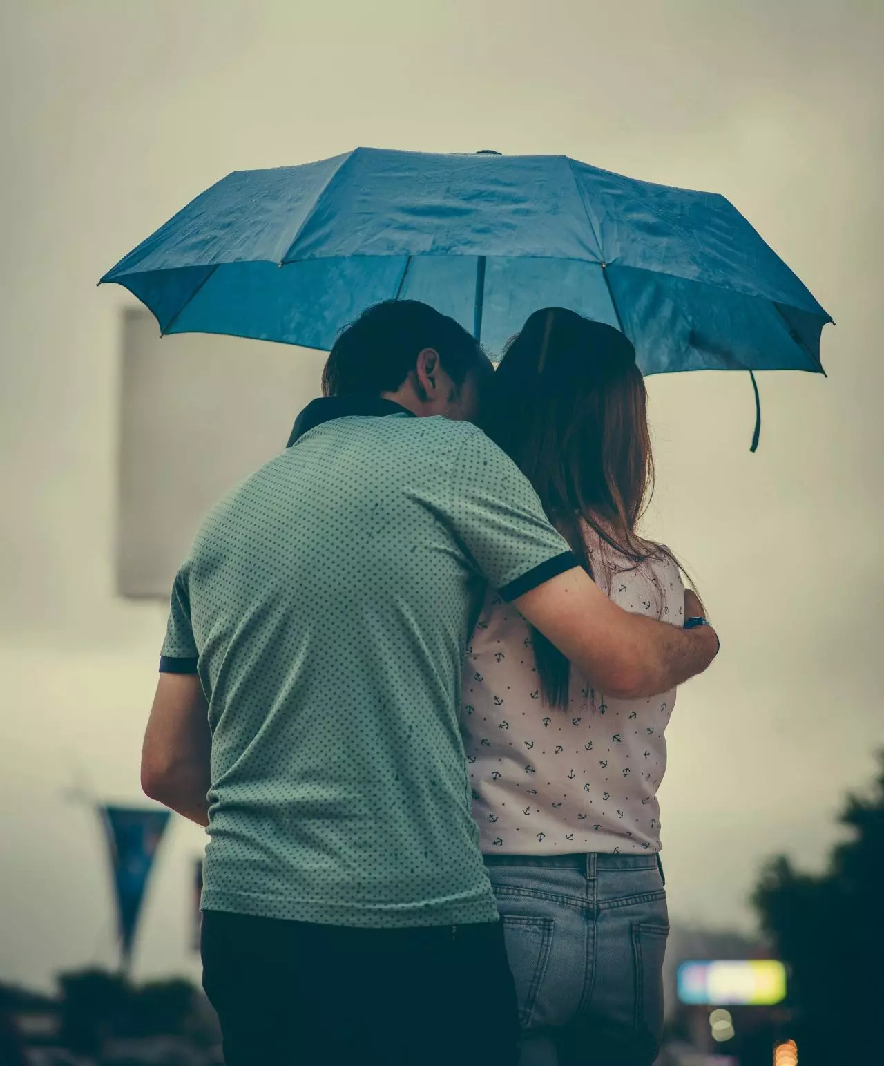 psychologue-yverdon-couple-2 Un couple de dos s'abritant sous un parapluie, symbolisant la protection et l'exploration des émotions dans une relation.